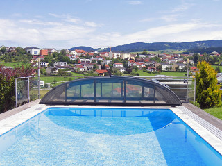 Antracitové provedení konstrukce bazénového zastřešení ELEGANT NEO™ Bazénové zastřešení ELEGANT NEO™ odsunuté za bazénem