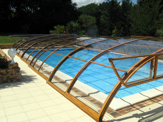 Zastřešení bazénu ELEGANT NEO™ s výklopnou částí v čelní stěně krytu na bazén Zastřešení bazénu ELEGANT NEO™ s otevřeným výklopným čelem